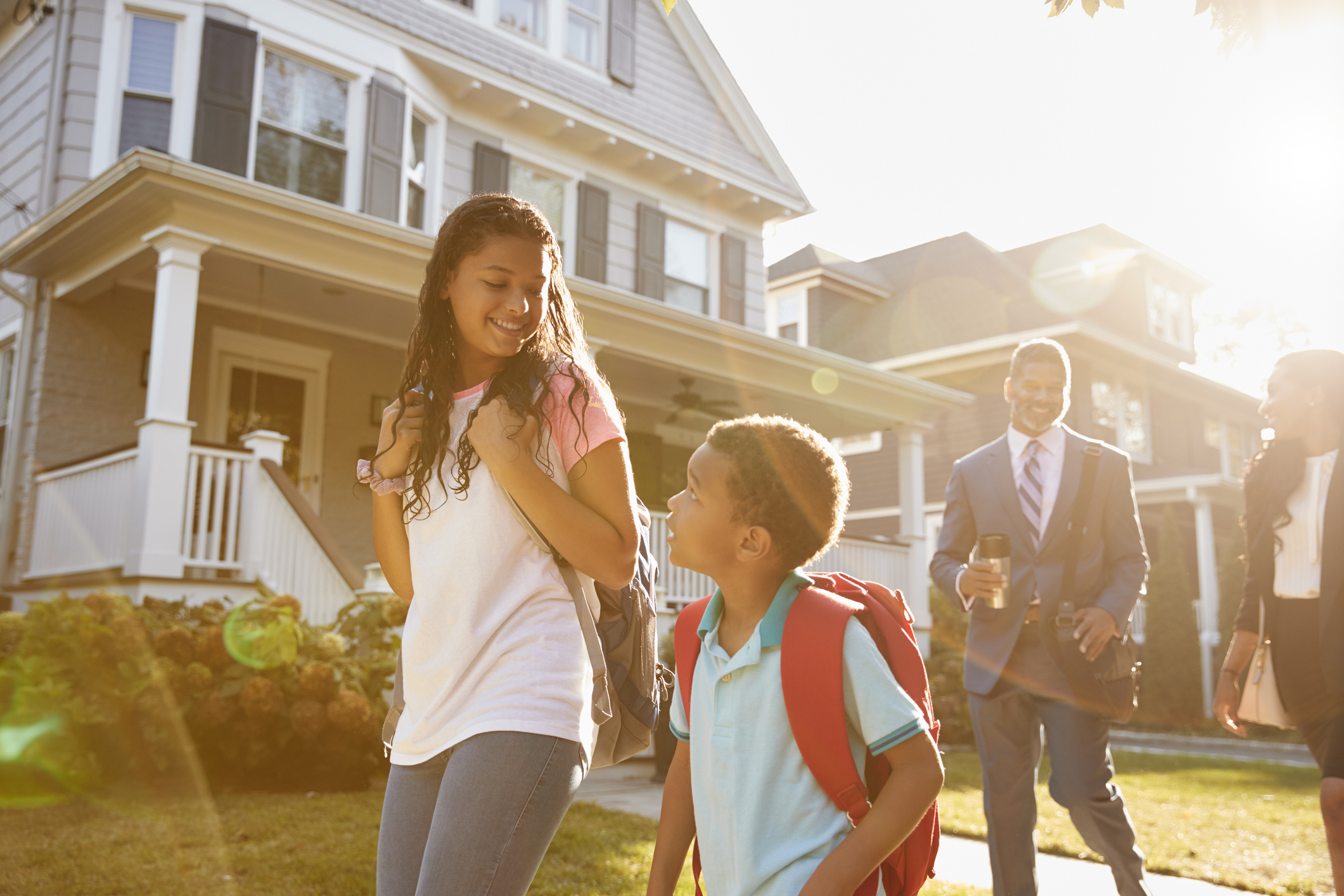 Businesswoman Parents Walking Children To School On Way To Work